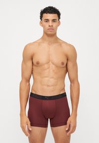 Boxer shorts vișinii cu o croială strânsă și un brâu elastic, având brandingul negru "PUMA". Material neted cu un design ergonomic al pungii.
