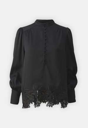 Blouse noire à manches longues avec un col haut, dotée d'un devant boutonné et de détails en dentelle complexes à l'ourlet. Tissu lisse, manches bouffantes.