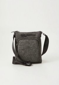 Pilkos medžiagos laižomas krepšys su priekinio užtrauktuko kišene ir reguliuojama petneša. Priekinė pusė puošta įspaustu logotipu „KARL LAGERFELD JEANS“. Kompaktiškas dizainas.