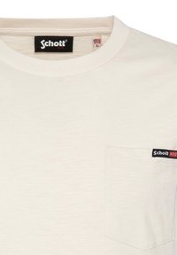 T-shirt di cotone beige chiaro con scollo rotondo, dotato di una piccola tasca sul petto sinistro e un'etichetta con il logo Schott NYC nera.