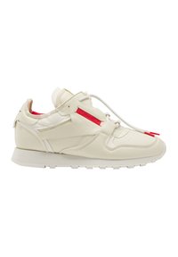 Baskets en cuir blanc avec un upper texturé, un design minimal, des accents rouges sur les côtés et une languette rembourrée. Semelle en caoutchouc plate.