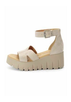 Sandali platform beige con cinturino alla caviglia, realizzati in materiale effetto suede, con design incrociato sulla tomaia e suola spessa e zigrinata.