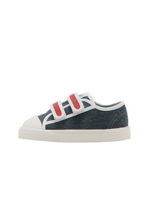 Baskets basses en denim foncé avec semelle blanche, bout renforcé et double bandes Velcro rouge et blanc.