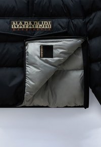 Giubbotto imbottito nero con un interno brillante di colore argento, caratterizzato da una grande patch logo sul petto e una tasca con zip sulla fodera interna.