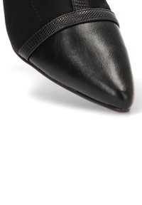 Zapato de punta negra con un upper de cuero suave y una banda texturizada en la parte frontal. El tacón es elegante y no muy alto.