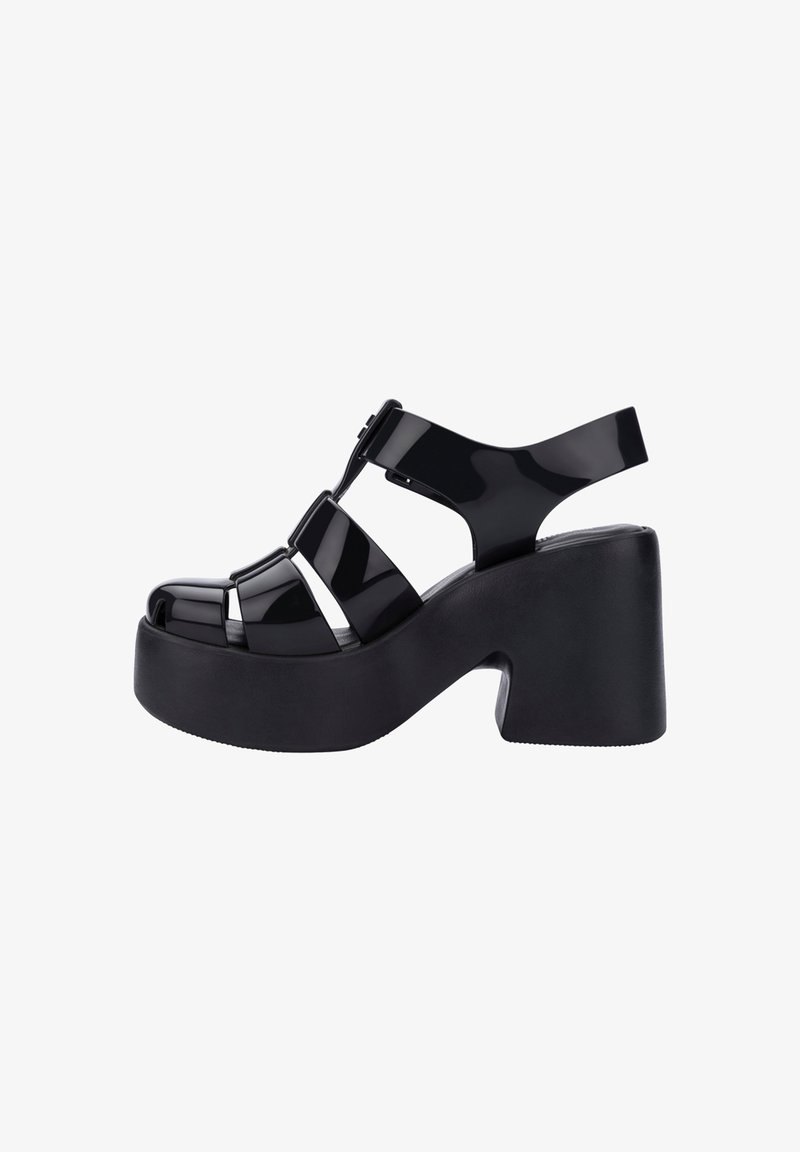 Sandales à plateforme en cuir verni noir avec un talon épais, un design ouvert à l'avant et des détails de lanières croisées.