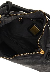 Interno di una borsa a tracolla in pelle nera con una zip dorata, texture liscia e rivestimento in tessuto. Presenta un'etichetta del produttore all'interno.