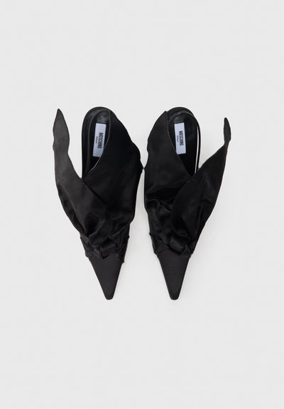 Czarne mulesy z tkaniny o spiczastym czubku, ozdobione falbankami i otwartym tyłem. Gładka faktura i minimalistyczna estetyka.