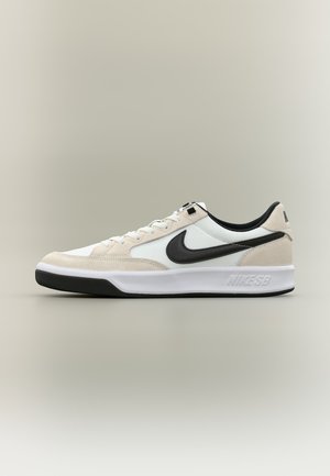 Nike SB madalad tossud beežist seemisnahast ja valgest võrgust pealsega, musta Swooshi logoga, musta voodriga ning valge tallaga, millel must tallaosa.
