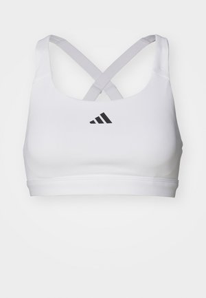 Top sportivo bianco con spalline incrociate e logo Adidas nero sul davanti. Realizzato in materiale liscio ed elastico con una vestibilità aderente.
