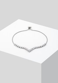 Silver-toned bracelet featuring a chevron design, adorned with clear, round crystals along a flexible chain.