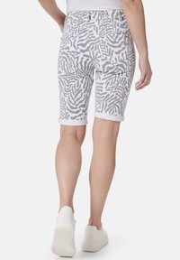 Weiße Denim-Bermuda-Shorts mit einem grauen Zebra-Print, umgeschlagenen Säumen und klassischen Gesäßtaschen. Lässiger Schnitt mit glatter Textur.
