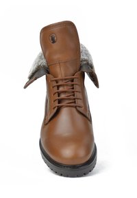 Bota de cuero marrón con cuello de piel gris, punta redondeada y suela de goma negra. Presenta un diseño con cordones y un logo en la lengüeta.