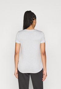 Tricou gri cu mâneci scurte, decolteu rotund și tiv curbat, realizat dintr-un material moale. Prezintă o croială lejeră și o textură subtilă.