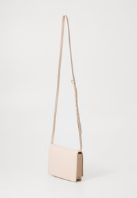 Borsa a tracolla rosa chiaro, realizzata in pelle liscia, forma rettangolare, tracolla regolabile, design minimalista senza hardware visibile.
