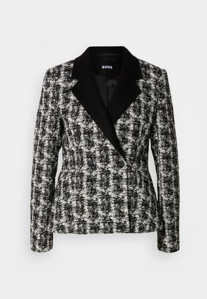 Čierno-biela, dvojradová sako s houndstooth vzorom, s klopami a čiernymi gombíkmi. Textúrovaná tkanina so štruktúrovaným strihom.