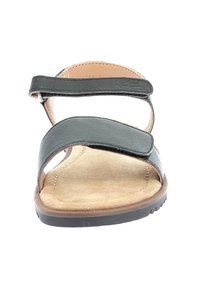 Sandal in pelle nera con punta aperta, doppie cinghie e chiusura regolabile in Velcro. Soletta morbida color beige e suola esterna in gomma testurizzata.