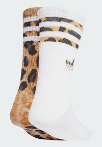 Zwei Paare Crew-Socken; eines hat ein braunes Leopardenmuster mit schwarzen Flecken, das andere ist einfarbig weiß mit schwarzen Streifen und Logo.