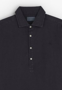 Donkerblauwe polo-shirt van katoen met een knoopsluiting, voorzien van een gestructureerde kraag en een klein geborduurd logo op de borst.