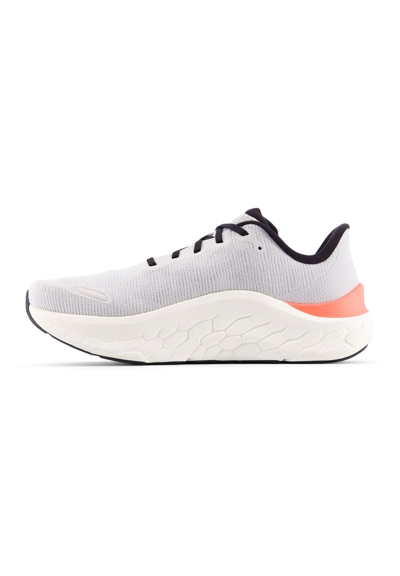 Zapatilla deportiva gris claro con parte superior de punto texturizado, detalles en negro y una entresuela de espuma blanca con un talón coral brillante.