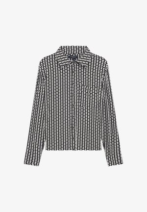 Camisa de manga larga con un patrón geométrico en blanco y negro, cuello puntiagudo, cierre de botones y un bolsillo en el pecho.