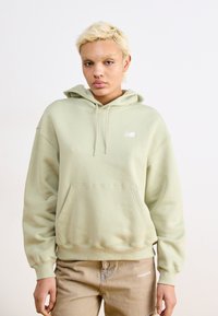 Hoodie verde menta com um bolso frontal e punhos canelados, apresentando um pequeno logo branco. Textura suave e design de corte descontraído.