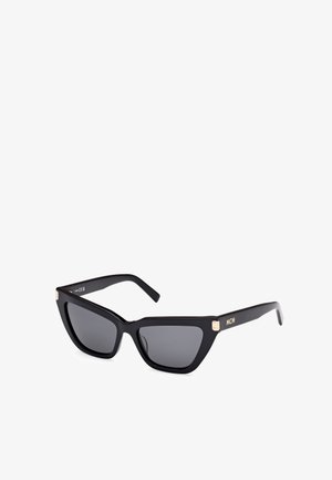 Czarne okulary przeciwsłoneczne w kształcie kociego oka o matowym wykończeniu, szare przyciemniane soczewki i złote akcenty. Marka "MCM" jest umieszczona na zauszniku.