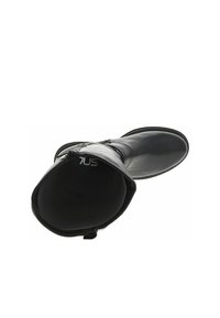 Bottine en cuir noir avec un bout rond, texture lisse et zippée sur le côté. L'intérieur est doté d'une doublure rembourrée pour le confort.