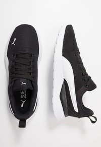 Black mesh athletic shoes with white accents and textured sole. Features lace-up design and padded collar for comfort.