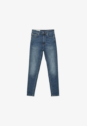 Jean skinny bleu avec détails délavés, poches avant, passants de ceinture et fermeture par bouton, présenté à plat sur un fond blanc.