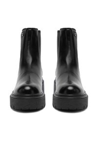 Para czarnych skórzanych botków za kostkę z grubymi, teksturowanymi podeszwami, okrągłymi noskami i elastycznymi bocznymi panelami, pokazana z przodu na białym tle.