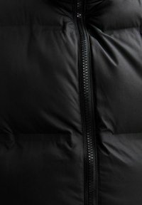 Czarna kurtka puchowa z centralnym zamkiem, pikowanym wzorem i gładką teksturą. Materiał wydaje się błyszczący z miękkim, izolowanym wykończeniem.