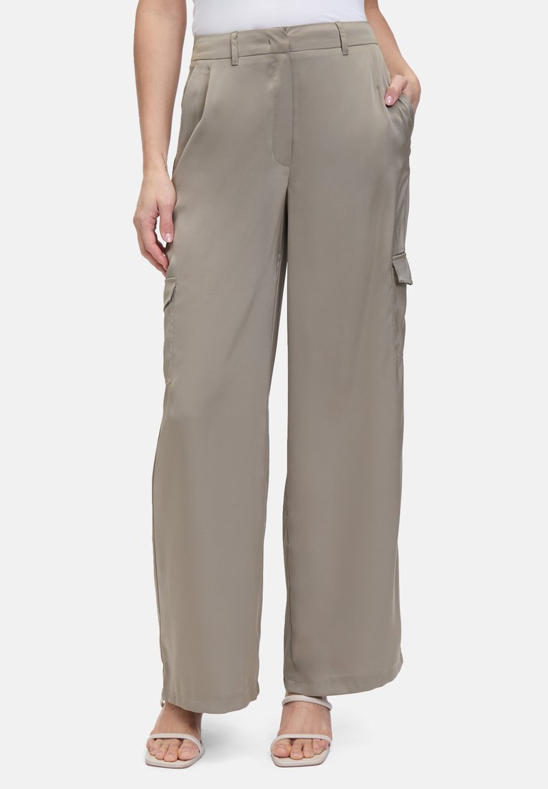 Wijdvallende cargobroek in lichtbeige met een gladde, matte textuur. Voorzien van zijzakken en riemlussen. Geschikt voor casual draag. 