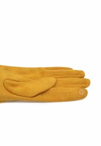 Guanto di suede giallo senape morbido con cinque dita, incluso un sottile dettaglio di ricamo a forma di fiore sulla punta del mignolo, steso su uno sfondo bianco.
