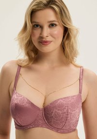 Fioletowy stanik z teksturowanym kwiatowym wzorem, wsparciem w postaci fiszbin, regulowanymi ramiączkami oraz złotym łańcuszkiem na środku.