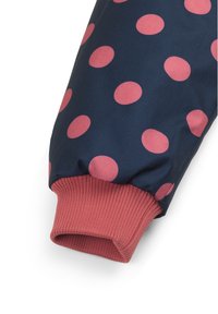 Tessuto a pois navy con cerchi rosa brillanti. Polsino a costine rosa elasticizzato alla fine, che offre una vestibilità aderente. Finitura in materiale testurizzato.