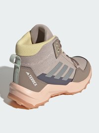 Gray and beige hiking shoe with a textured upper, padded collar, and rubber outsole; features three stripes logo and rear loop.