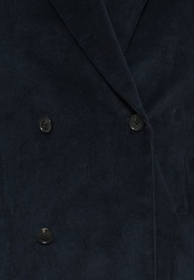 Saco dublu din catifea corduroy de culoare bleumarin, cu rever înțepat și două butoane negre, având un material texturat și un design structurat.