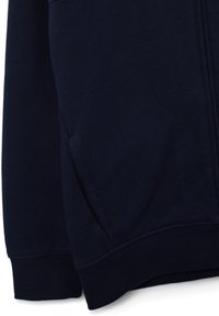 Sudadera azul marino con mangas y dobladillo inferior de canalé, con un bolsillo lateral visible sobre un fondo liso.