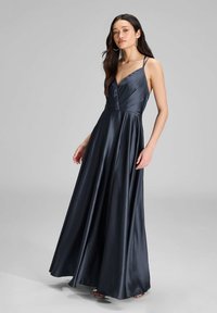Abito lungo da sera in satin blu nave, caratterizzato da scollo a V, spalline sottili e una gonna fluida con spacco laterale. Le pieghe testurizzate aggiungono un tocco di eleganza.
