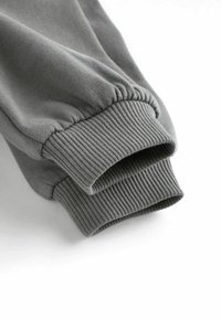 Grå sweatshirt-ærmer med en blød tekstur, ribbet finish og elastiske kanter. Simpelt og ubemærket design.