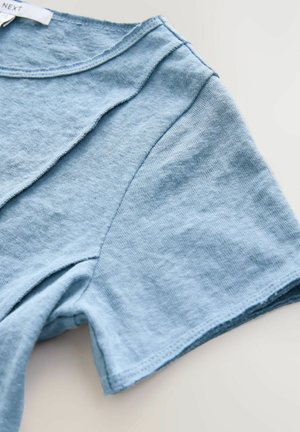 Svijetloplava pamučna majica s okruglim izrezom, kratkim rukavima i zakrivljenim šavovima na prednjoj strani. Mekana tekstura i ležeran dizajn.