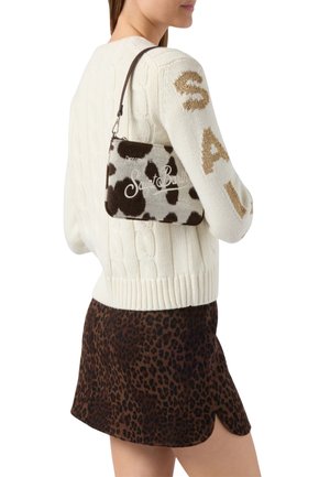Sac à main à imprimé vache marron et blanc avec le texte "Saint Barth", sangle attachée, présenté avec un pull en tricot crème et une jupe à imprimé léopard.