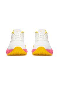 Pár bielych športových topánok so žltými a ružovými podrážkami, bielymi šnúrkami a žltým lemovaním, zobrazených z prednej strany na bielom pozadí.