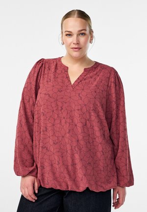 Rode bloemenblouse met een V-hals, lange mouwen en geplooide details bij de schouders. Heeft een geschulpte zoom en een subtiel patroon.