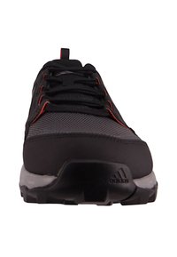 Front view of black and grey Adidas athletic shoe with red accents and black laces on a white background.