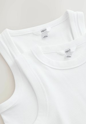 Two white ribbed tank tops with NEXT brand labels, made in Bangladesh, shown folded on a light background.