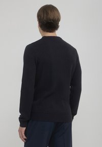 Navy gestrickter Pullover mit strukturiertem Stoff, gerippten Bündchen und Saum sowie einem Rundhalskragen. Bietet eine lässige Passform und ein dezentes Muster.