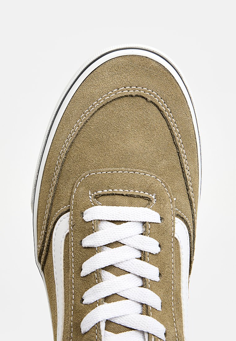 Suede-Sneaker in olivgrün mit weißen Schnürsenkeln, einem weißen Seitestreifen und kontrastierenden Nähten. Abgerundete Zehenpartie und Low-Top-Design.