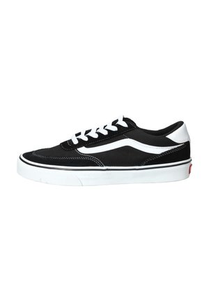 Zapatilla de lona negra con cordones blancos, una franja de acento blanca y suela de goma. Presenta detalles de costura y un diseño clásico de corte bajo.